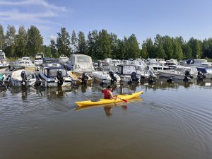 Joensuun Tilas båthamn, båtar i bryggan och en person i en kajak.