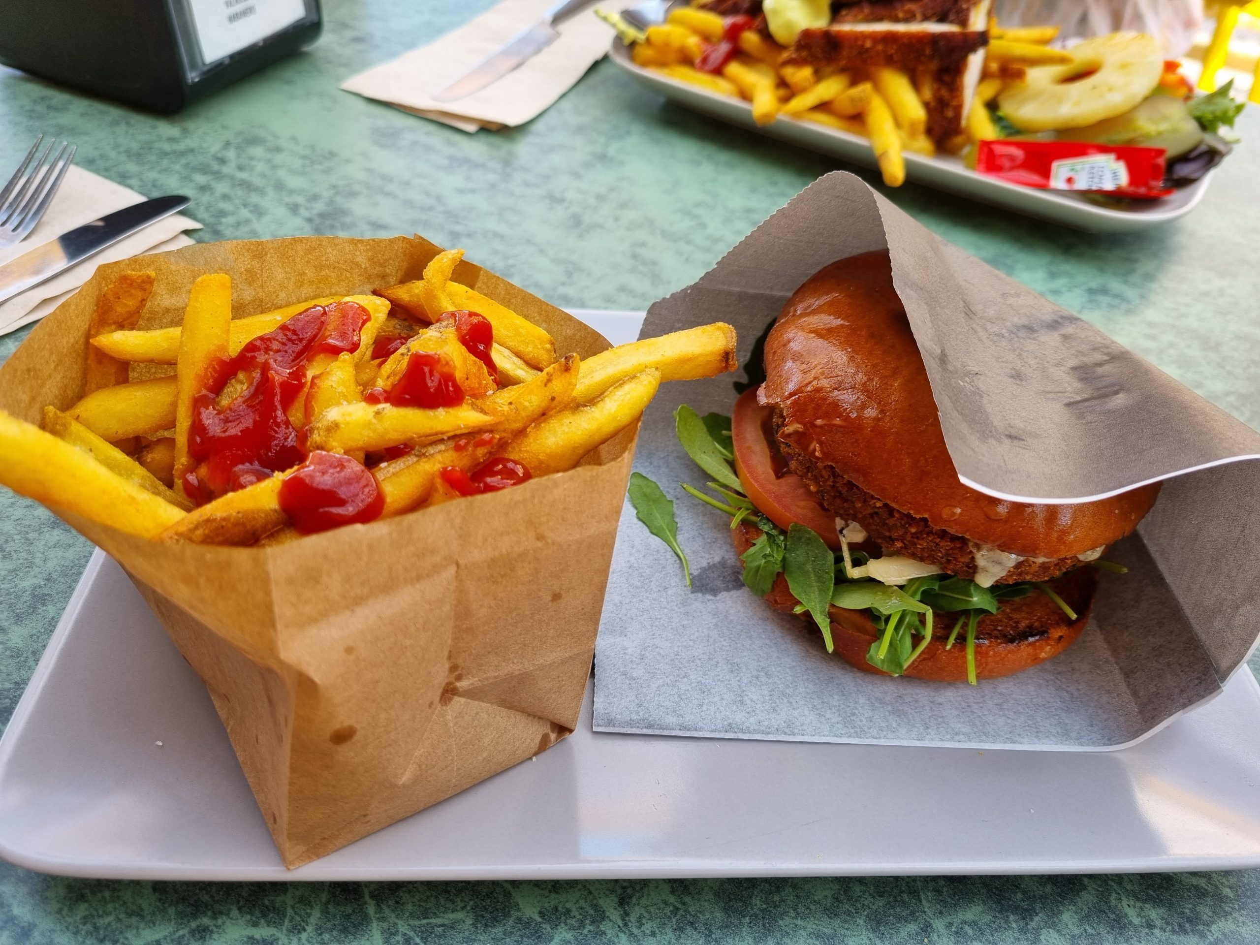 En burger och pommes frites på ett bord.