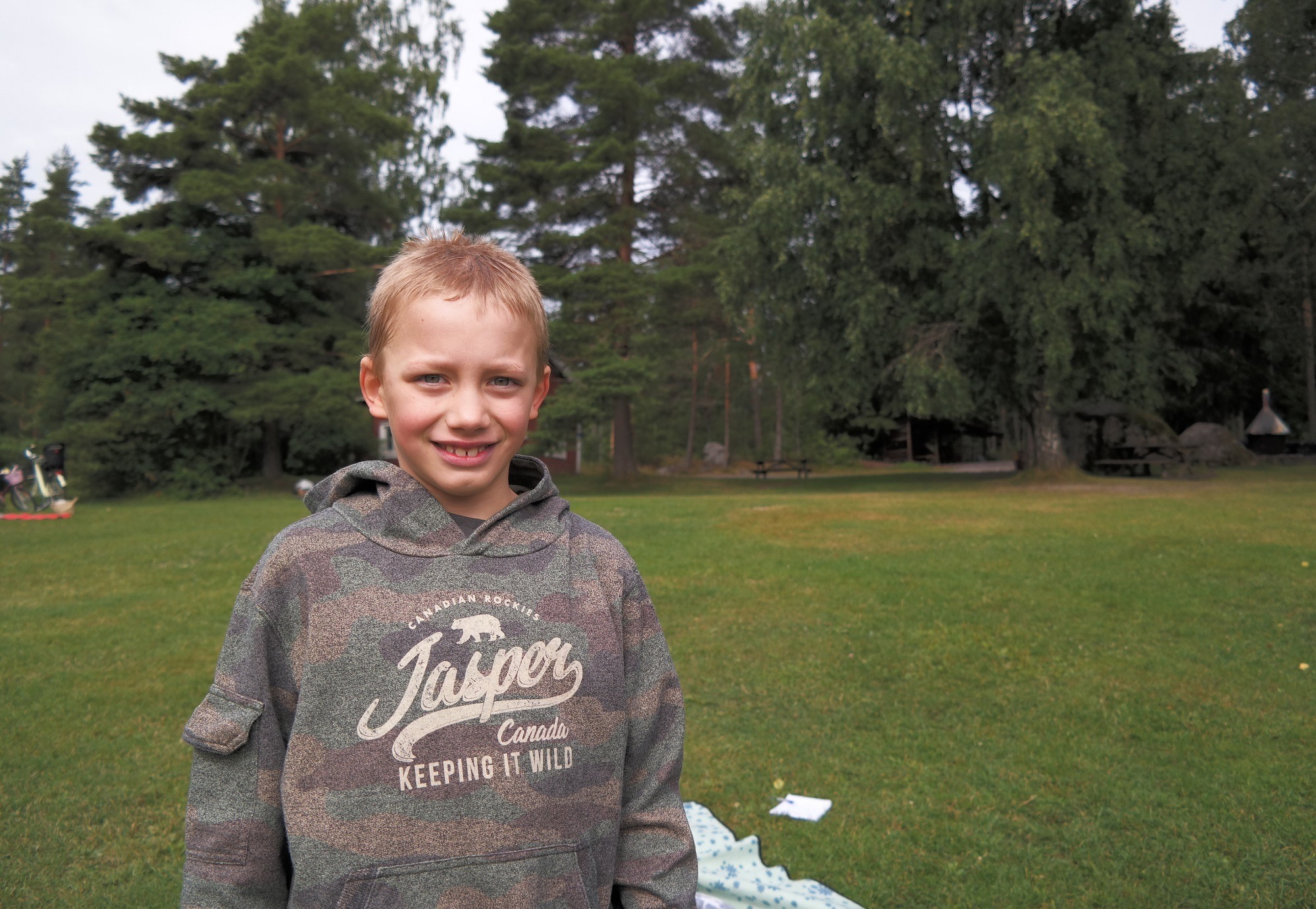 Hans Arnold ler. Bakom honom skog och en gräsmatta.