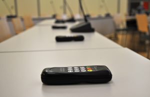 Valtuustosalissa pöydällä äänestykapuloita ja mikrofonit.